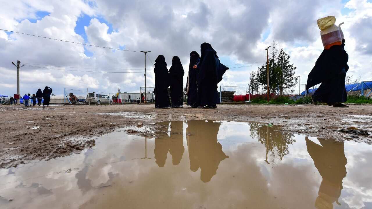 Women living inside Al-Hawl camp which houses relatives of Islamic State group members, walk inside the site in al-Hasakeh governorate in northeastern Syria.