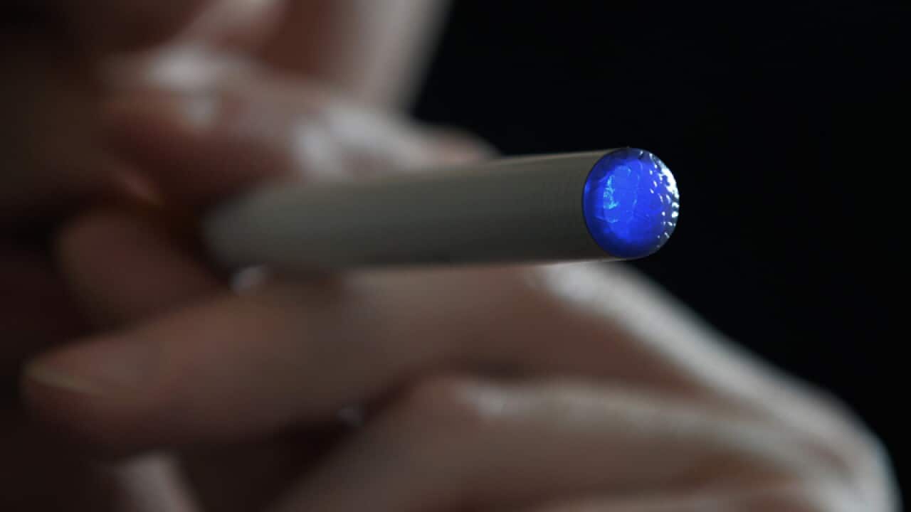 A person smokes an e-cigarette