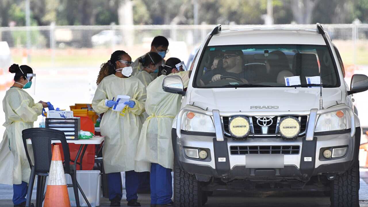 Health workers test the public at a drive through COVID testing site at Victoria Park in Adelaide.