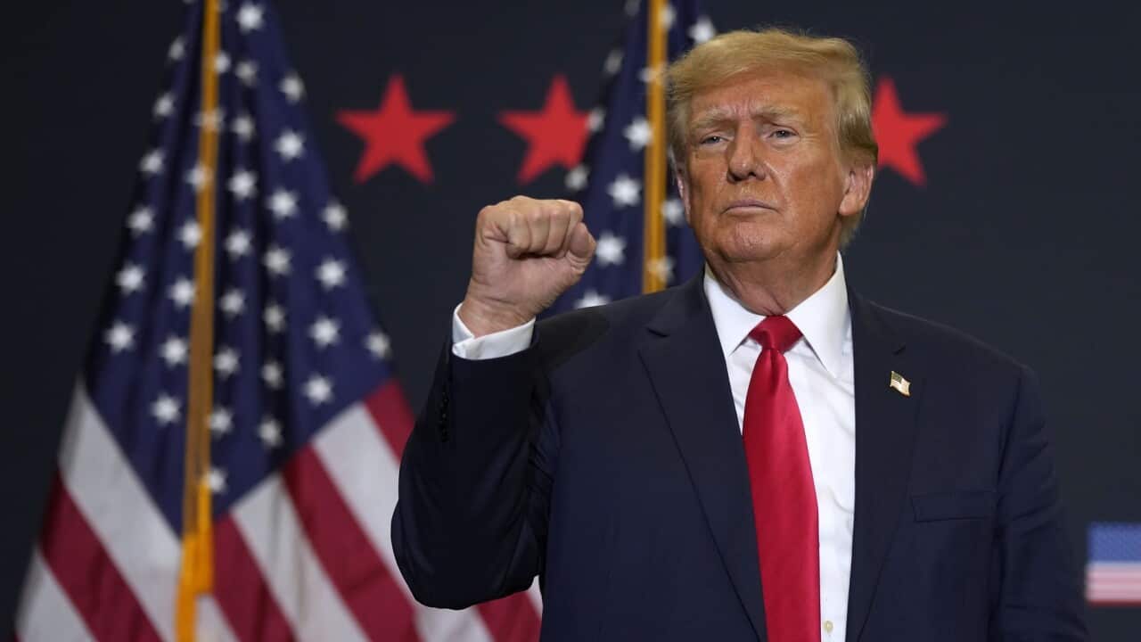 Former President Donald Trump reacts to supporters during a commit to caucus rally (AAP)