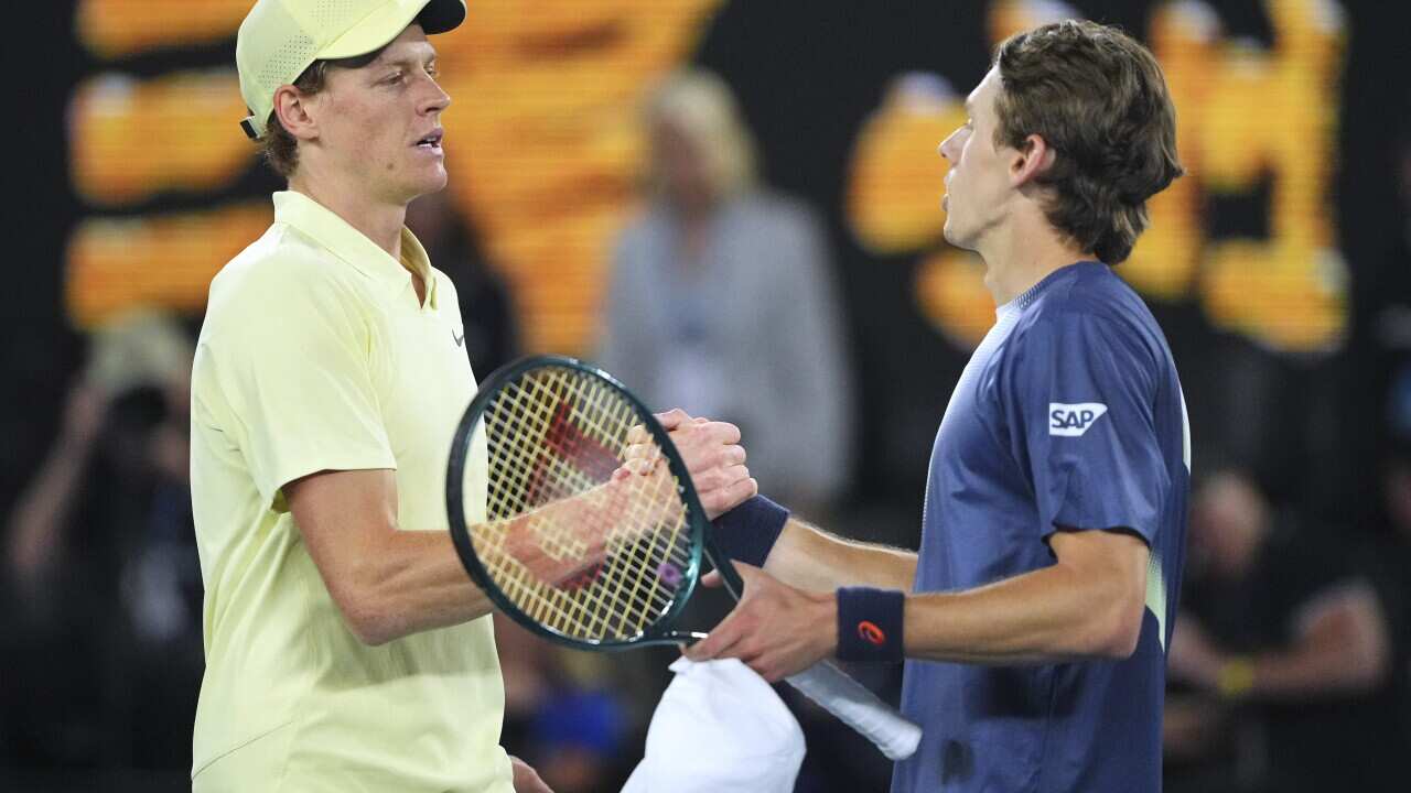 Two tennis players congratulate each other at the net.