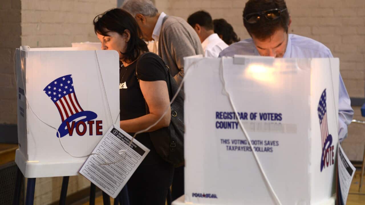 Voters consider their ballots in voting booths in California