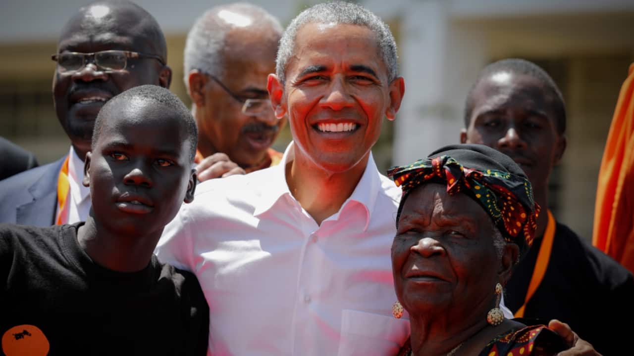 Former US president Barack Obama (C) poses for photographs with his step-grandmother Sarah Onyango Obama (R)