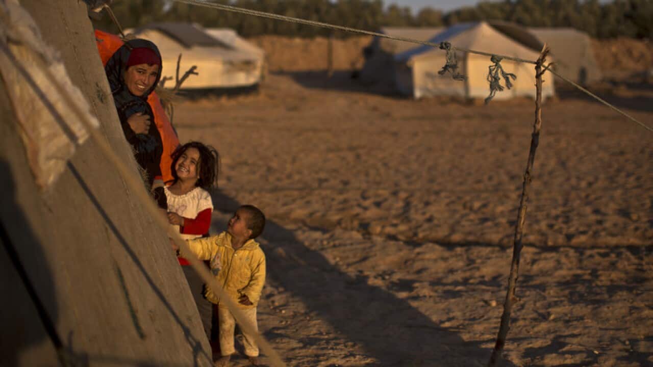 A Syrian refugee woman and her children