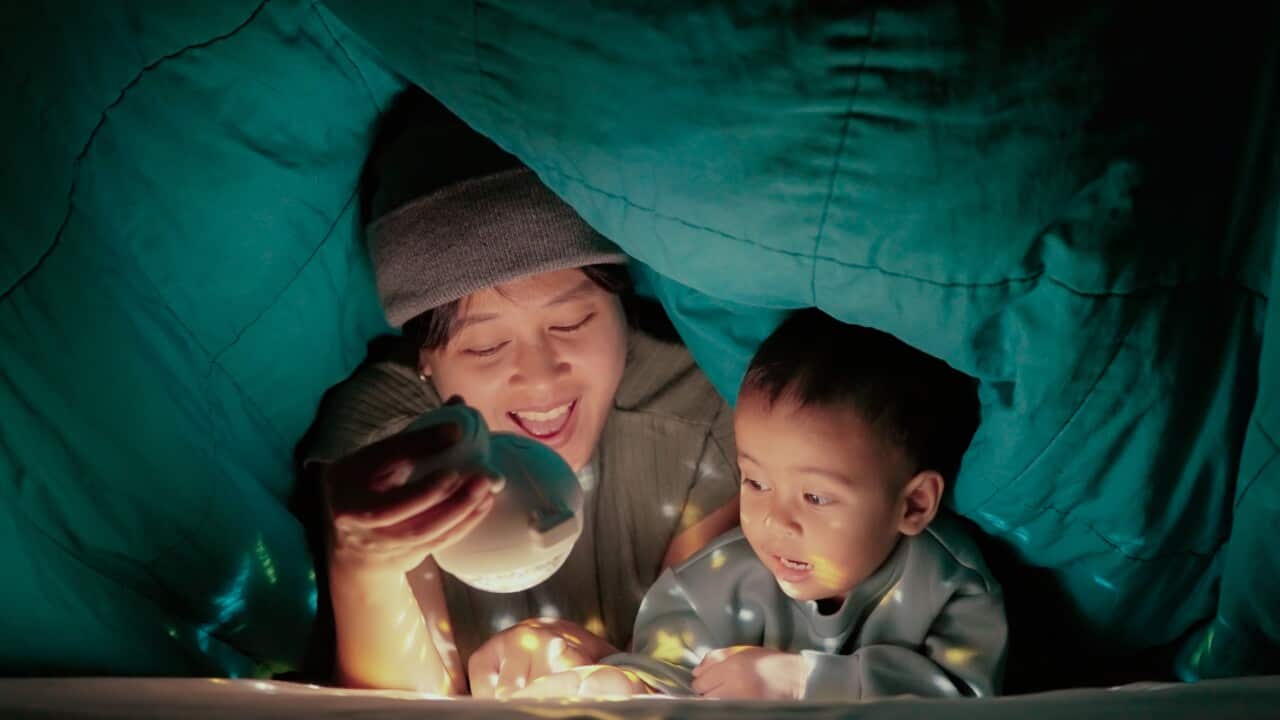 Mom and baby boy reading novel in bedroom