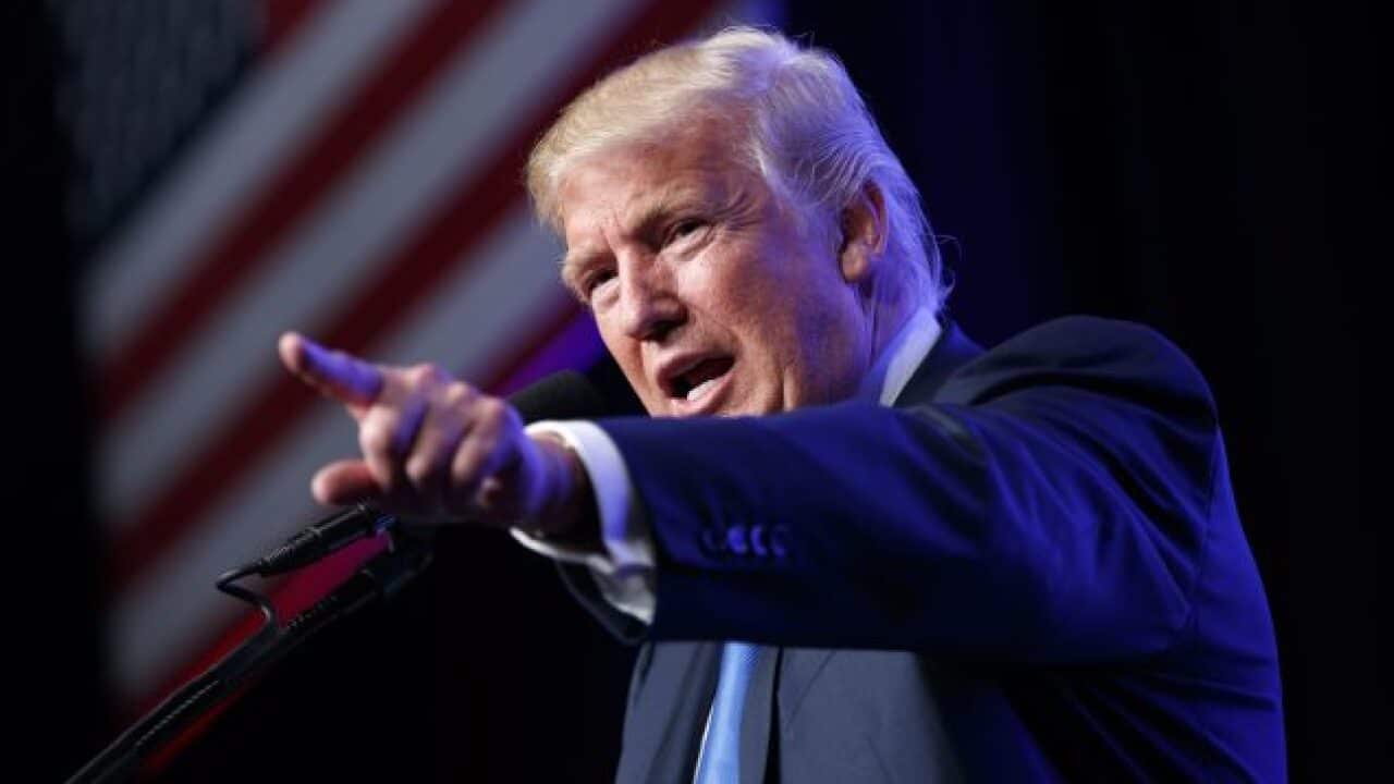 A man in a suit points a finger.