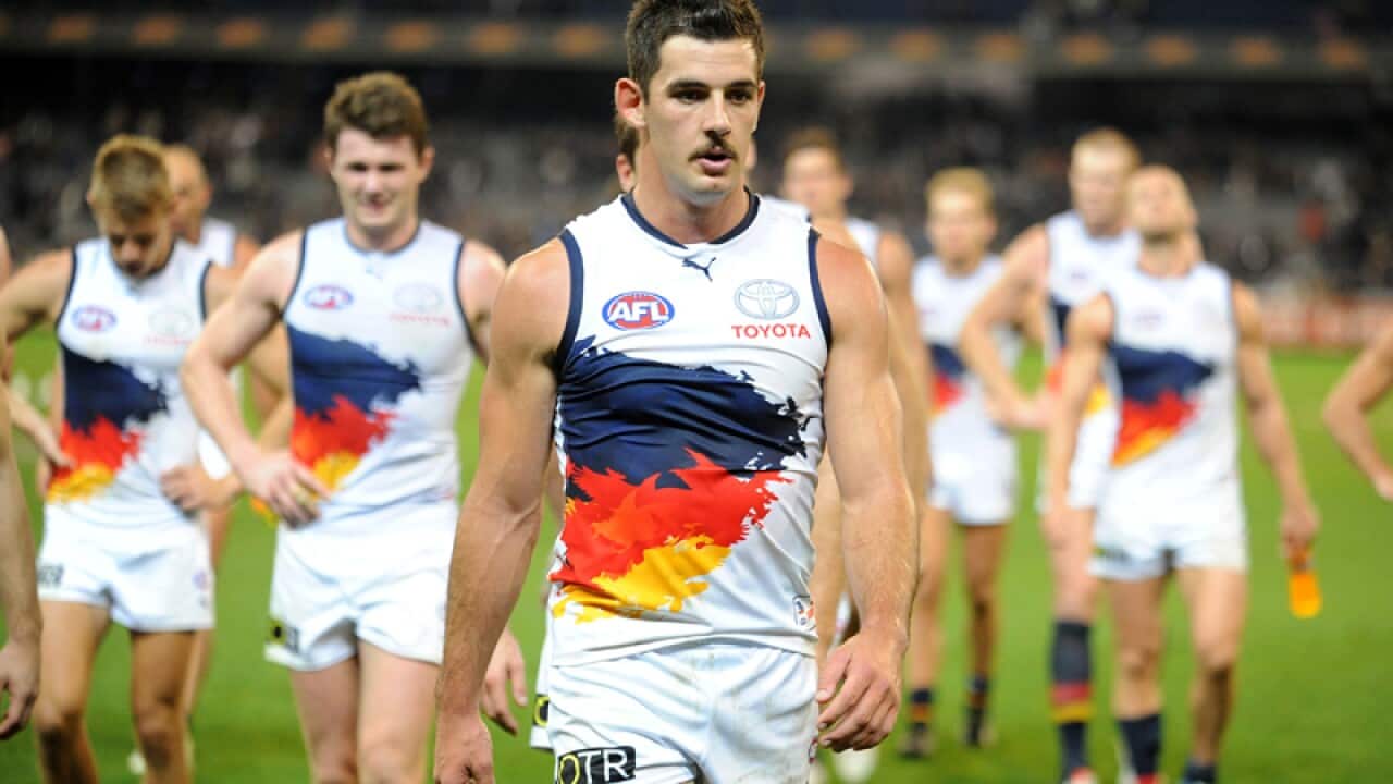 Adelaide Crows players leave the field