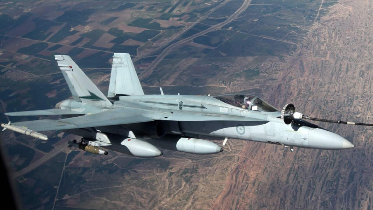 A RAAF F/A-18A Hornet aircraft air to air refuels.