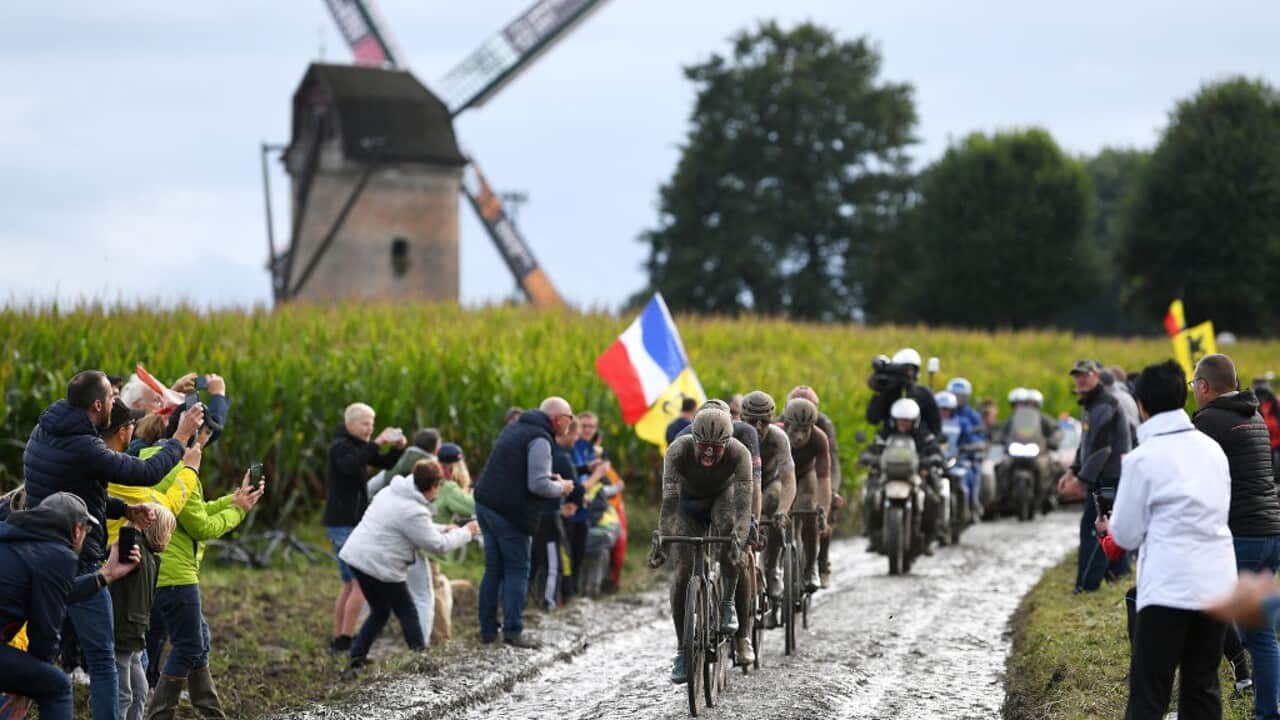 Riders traverse the cobble-covered Paris-Roubaix course