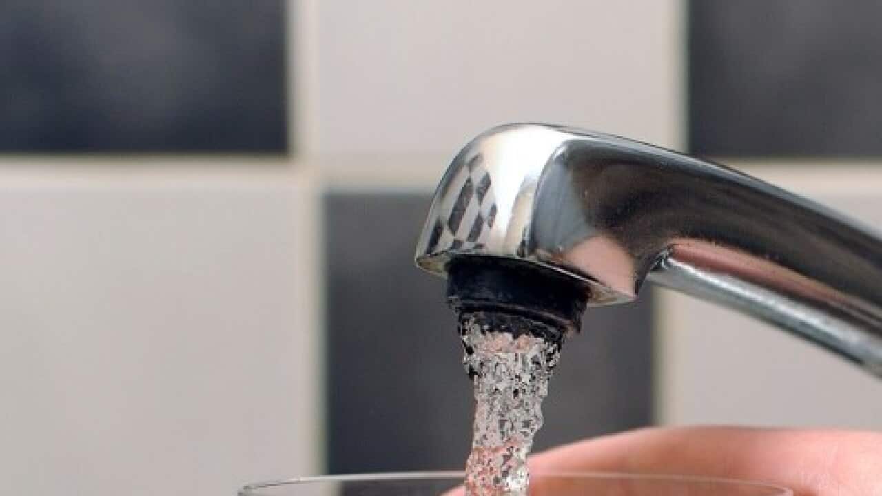 Tap water being poured from a tap in to a glass