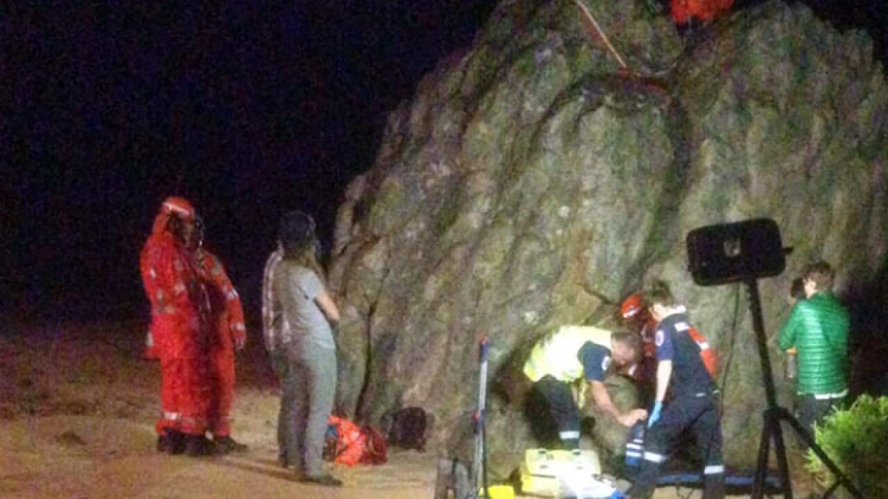 Rescue workers attempt to free a man trapped in a crevice