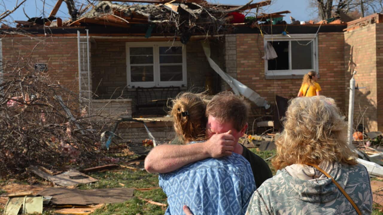 Ray Baughman embraces family after his home was destroyed.