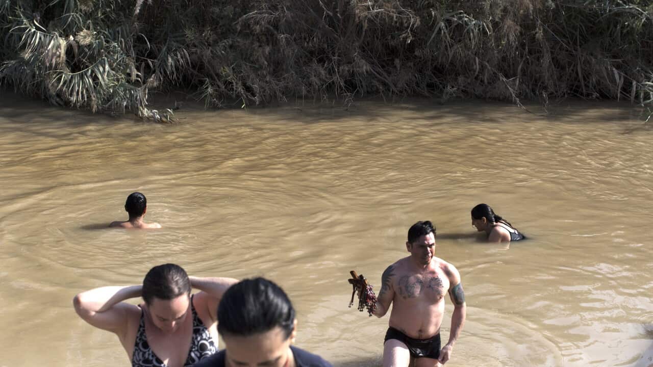 Pilgrims bath in the muddy waters of the Jordan River at the Qasr al-Yahud baptism site. (EPA)