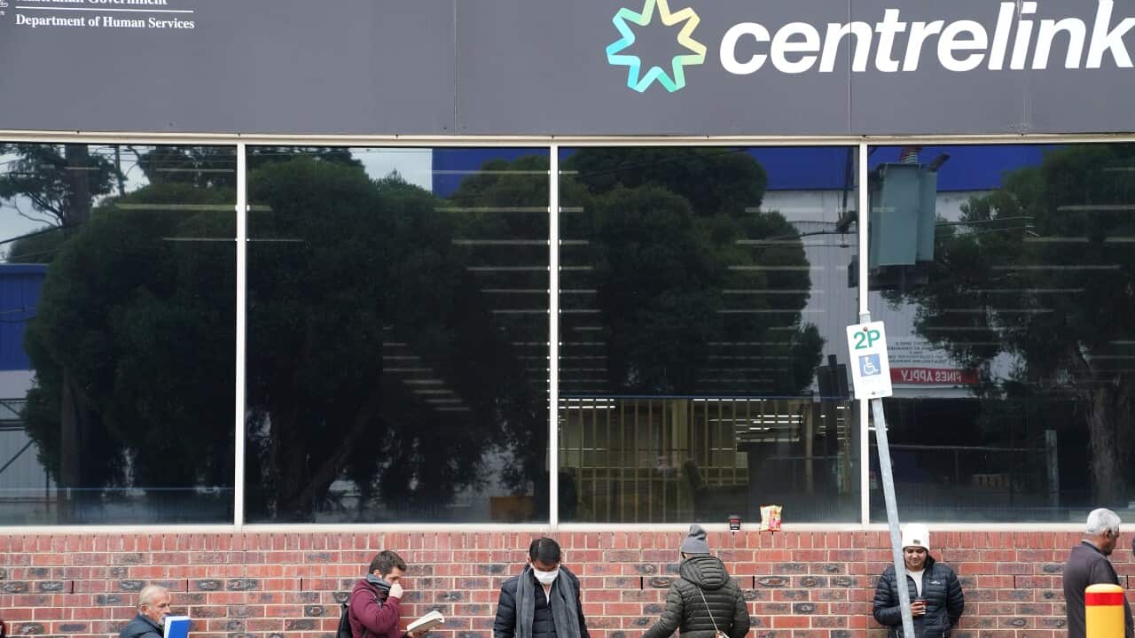 People are seen queuing outside a yet to open Centrelink office in Heidelberg, Melbourne,