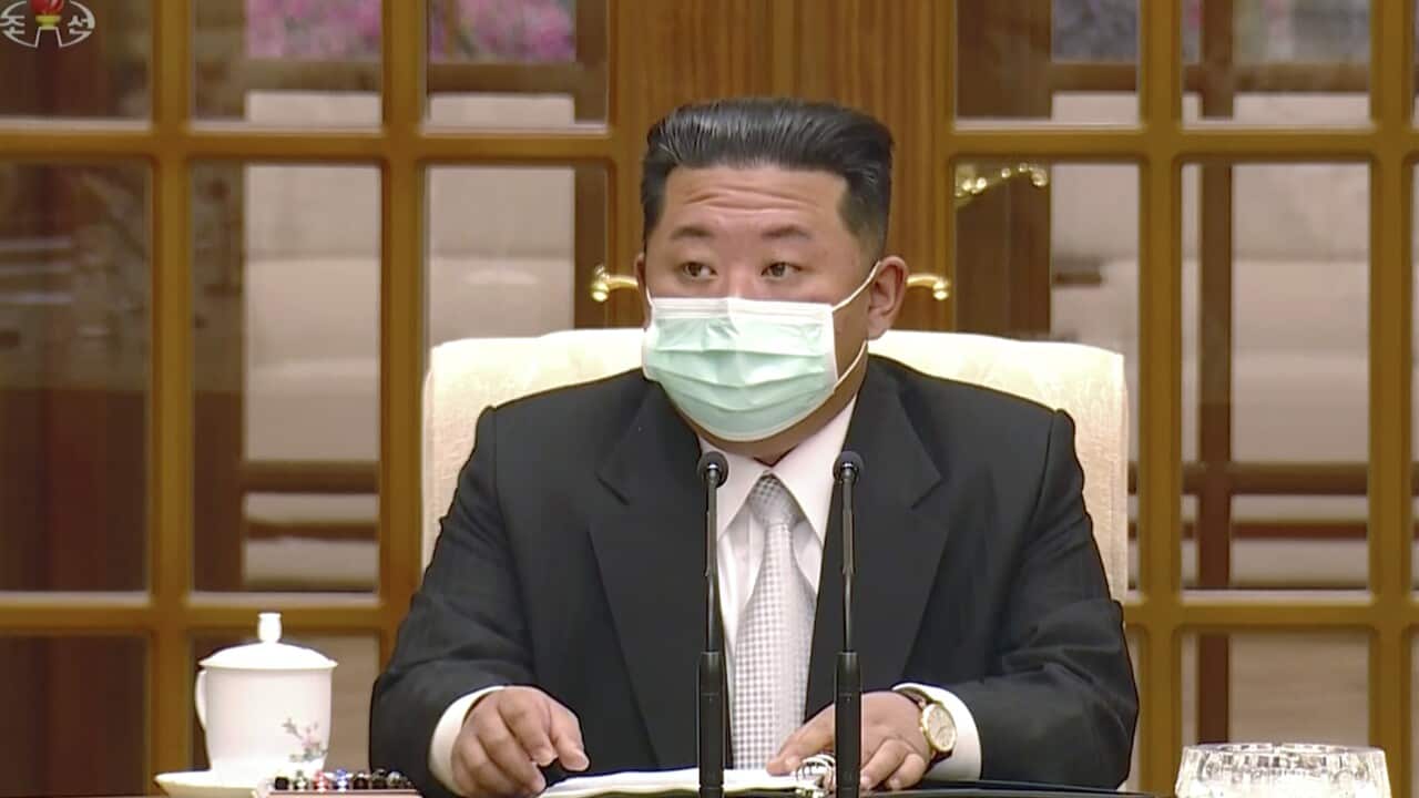 North Korean leader Kim Jong Un wears a face mask on state television during a meeting