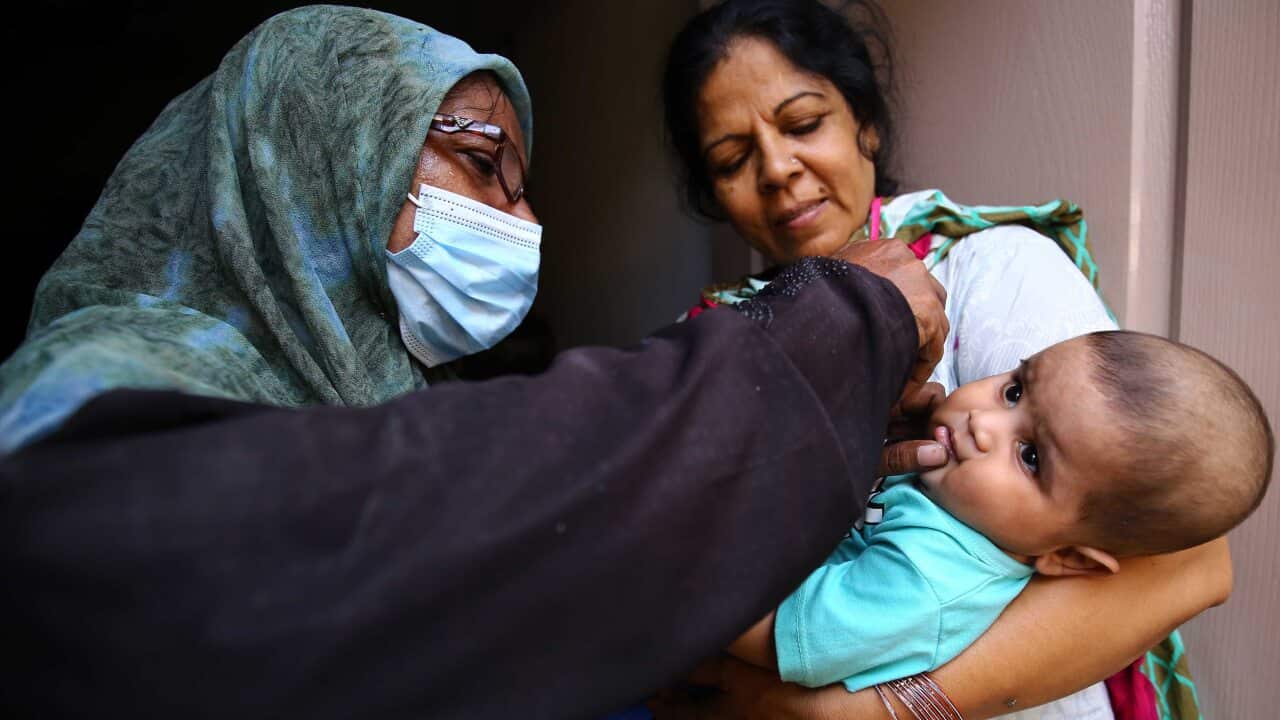 A health worker administers polio vaccine to children during a polio vaccination door-to-door campaign in Karachi, Pakistan, 23 September, 2020.