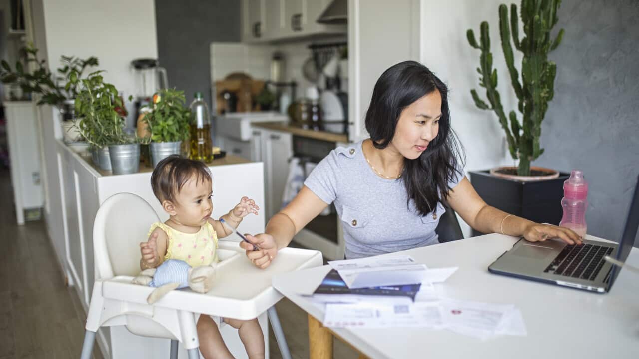 Young Asian mother working and spending time with baby at home
