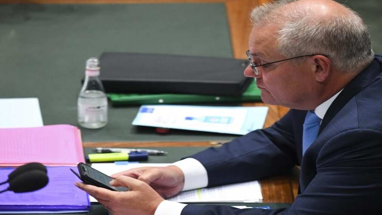PM Scott Morrison looking at mobile phone at Question Time