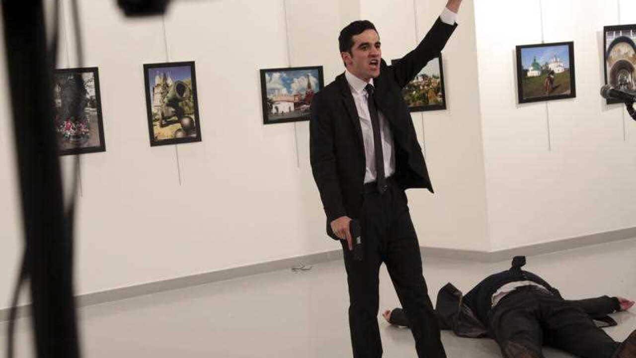 An unnamed gunman shouts after shooting the Russian Ambassador to Turkey, Andrei Karlov, at a photo gallery in Ankara, Turkey, Monday, Dec. 19, 2016.