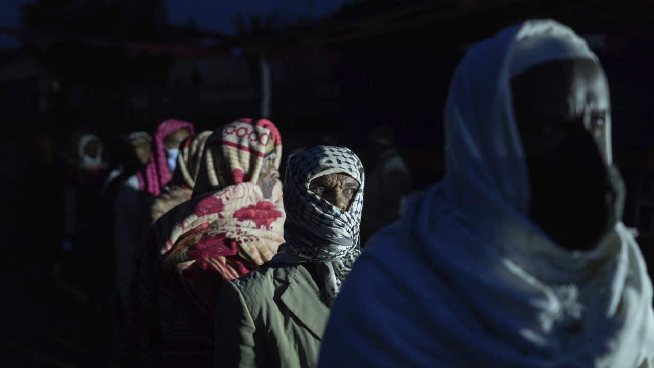 Ethiopians line up to cast vote in the general election in his home town of Beshasha, in the Oromia region of Ethiopia Monday, June 21, 2021.