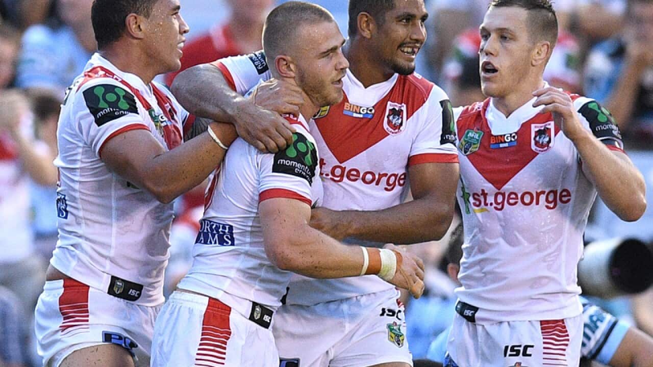 Euan Aitken of the Dragons, (second left), celebrates with team mates