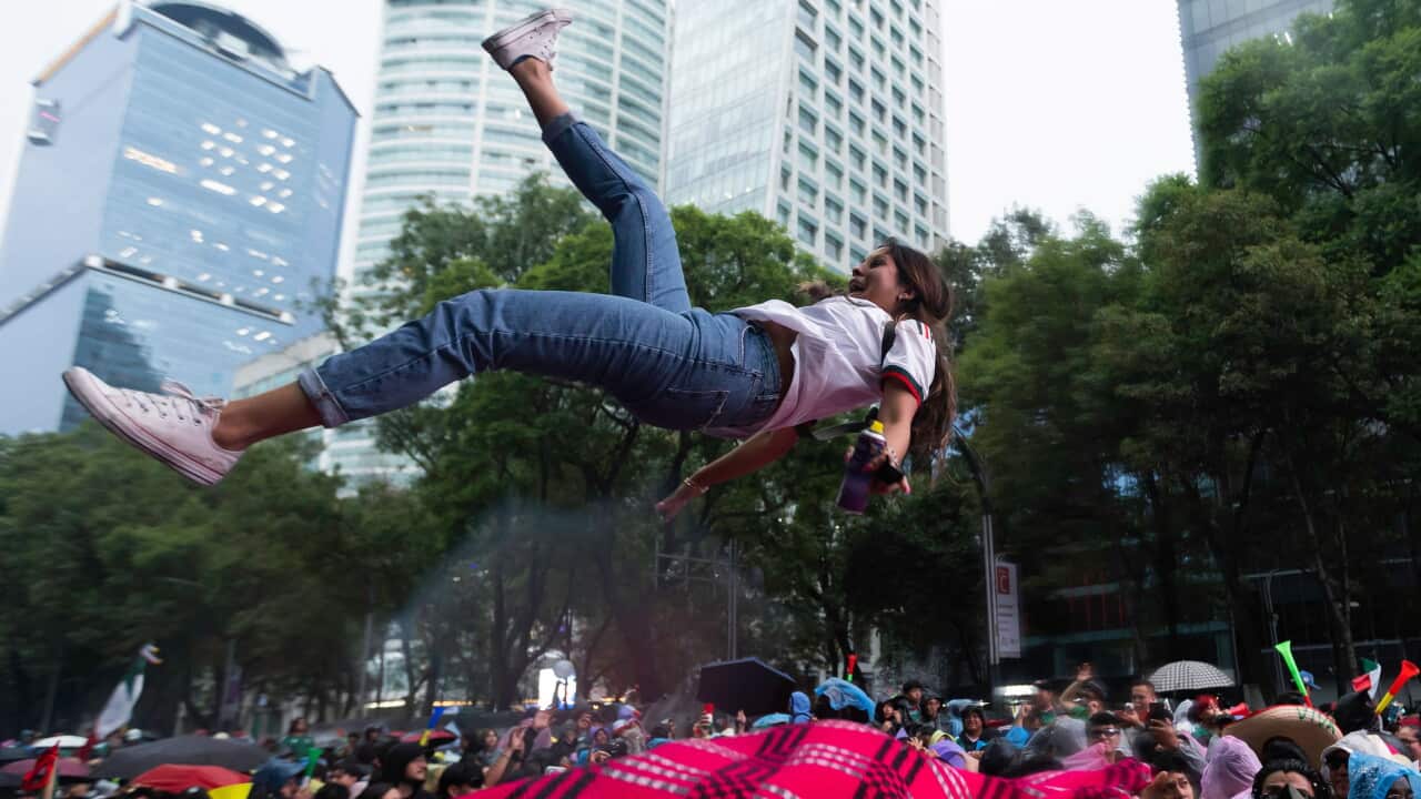 Fans gather around the Angel of Independence to celebrate Mexicos victory over Ecuador.