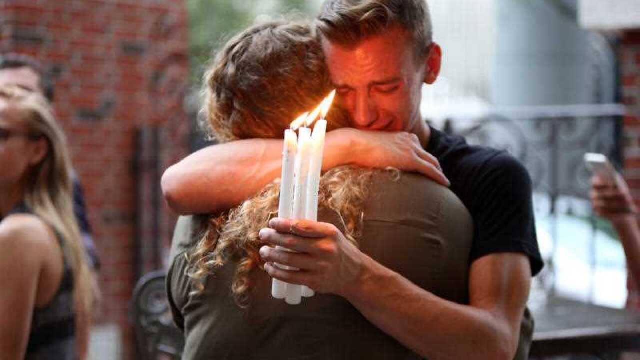 Brett Morian, from Daytona Beach, hugs an attendee during the candlelight vigil. (AP)