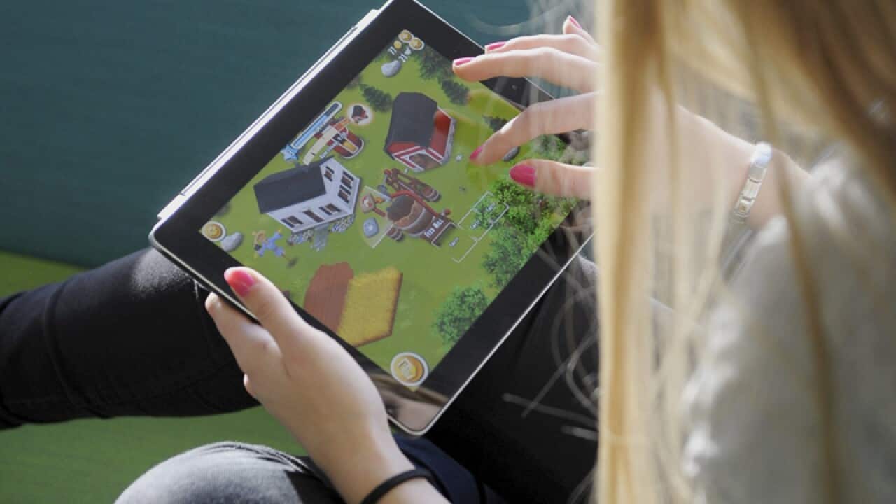 A girl plays a game on an iPad