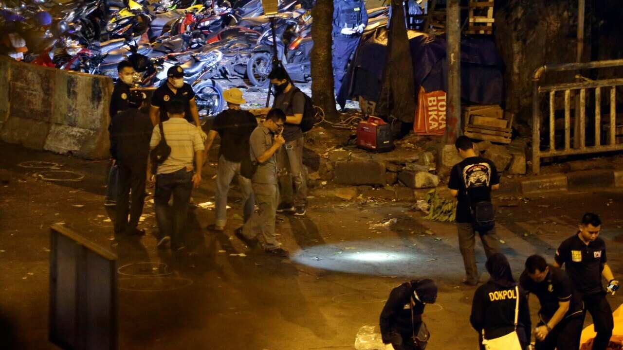 Body bags are lined up as police officers conduct their investigation near the site in Jakarta (AAP)