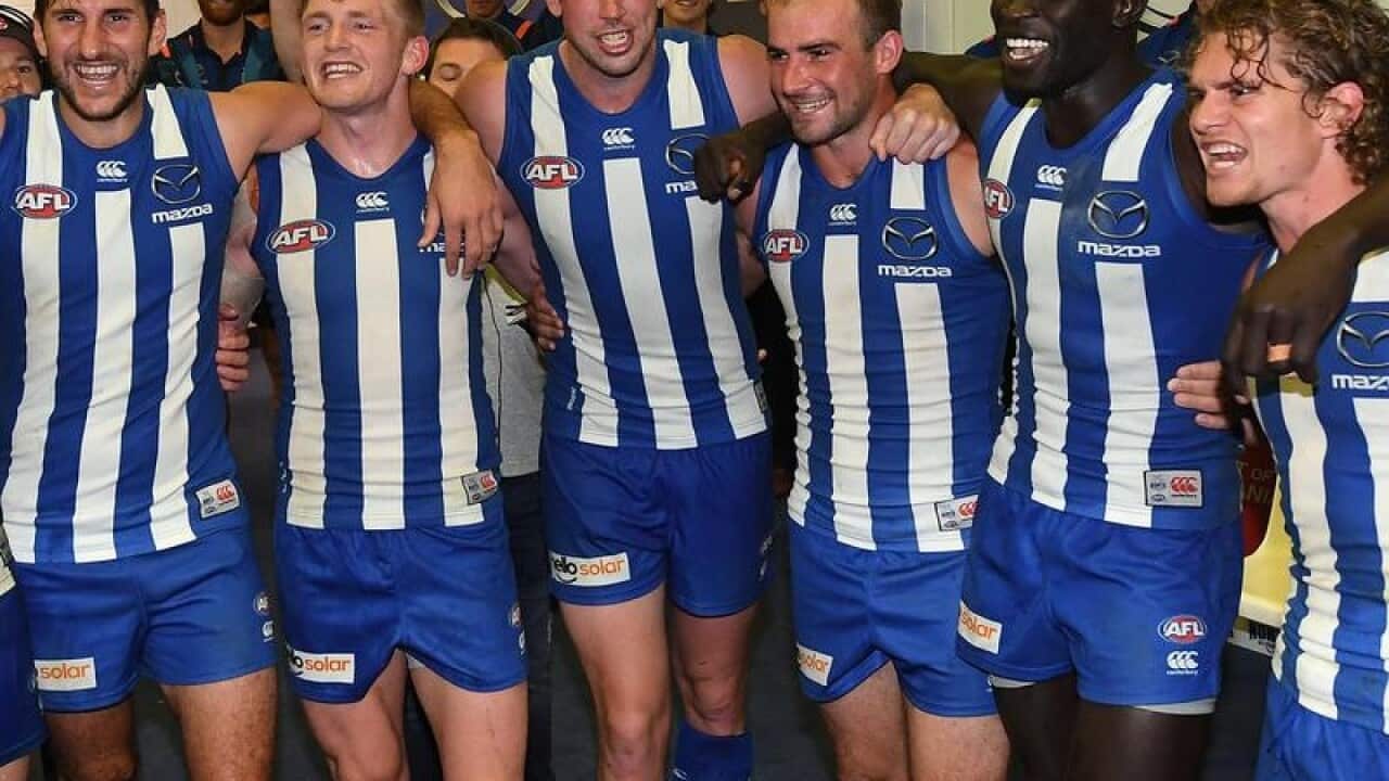 Kangaroos players sing the club song after winning Round 5.