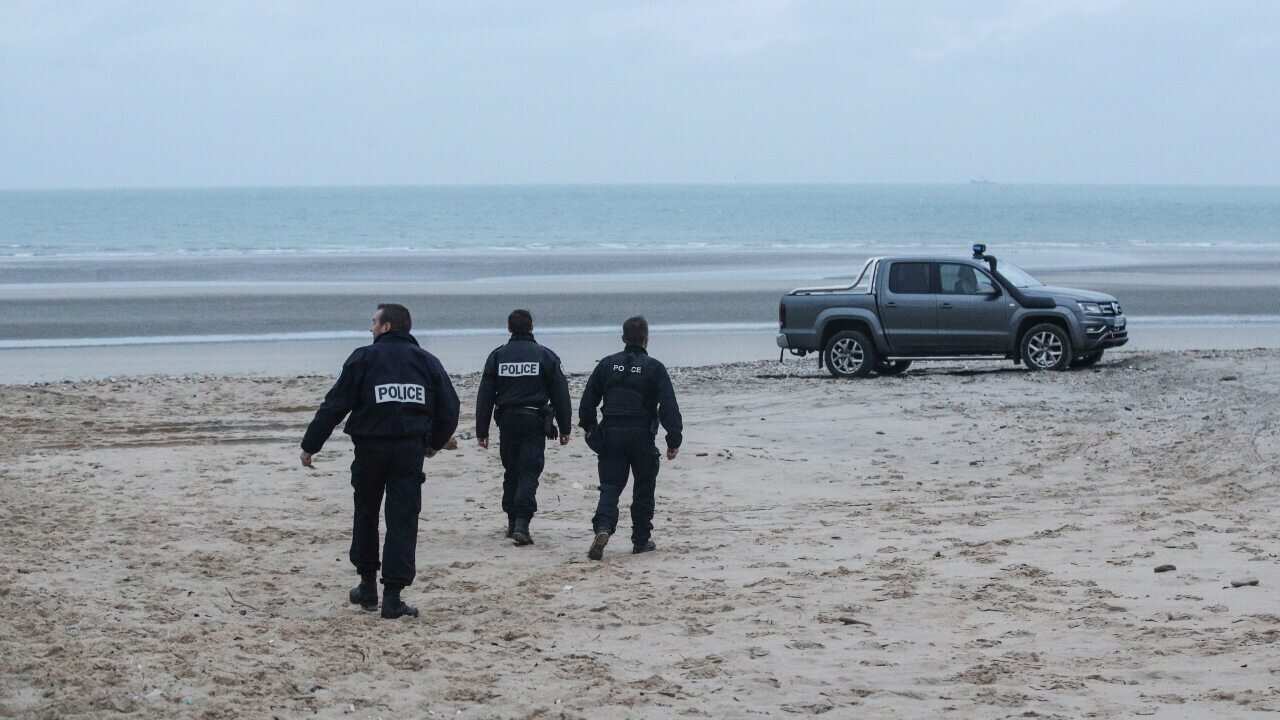 Policemen inspect the beach near Wimereux, France