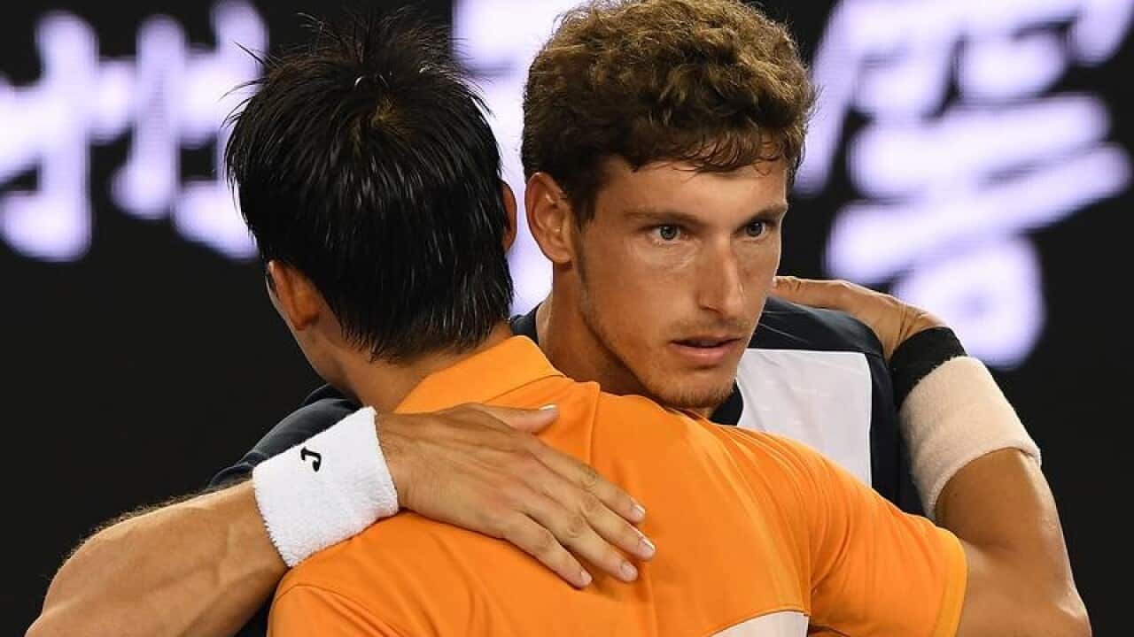 Kei Nishikori beats Pablo Carreno Busta (r).