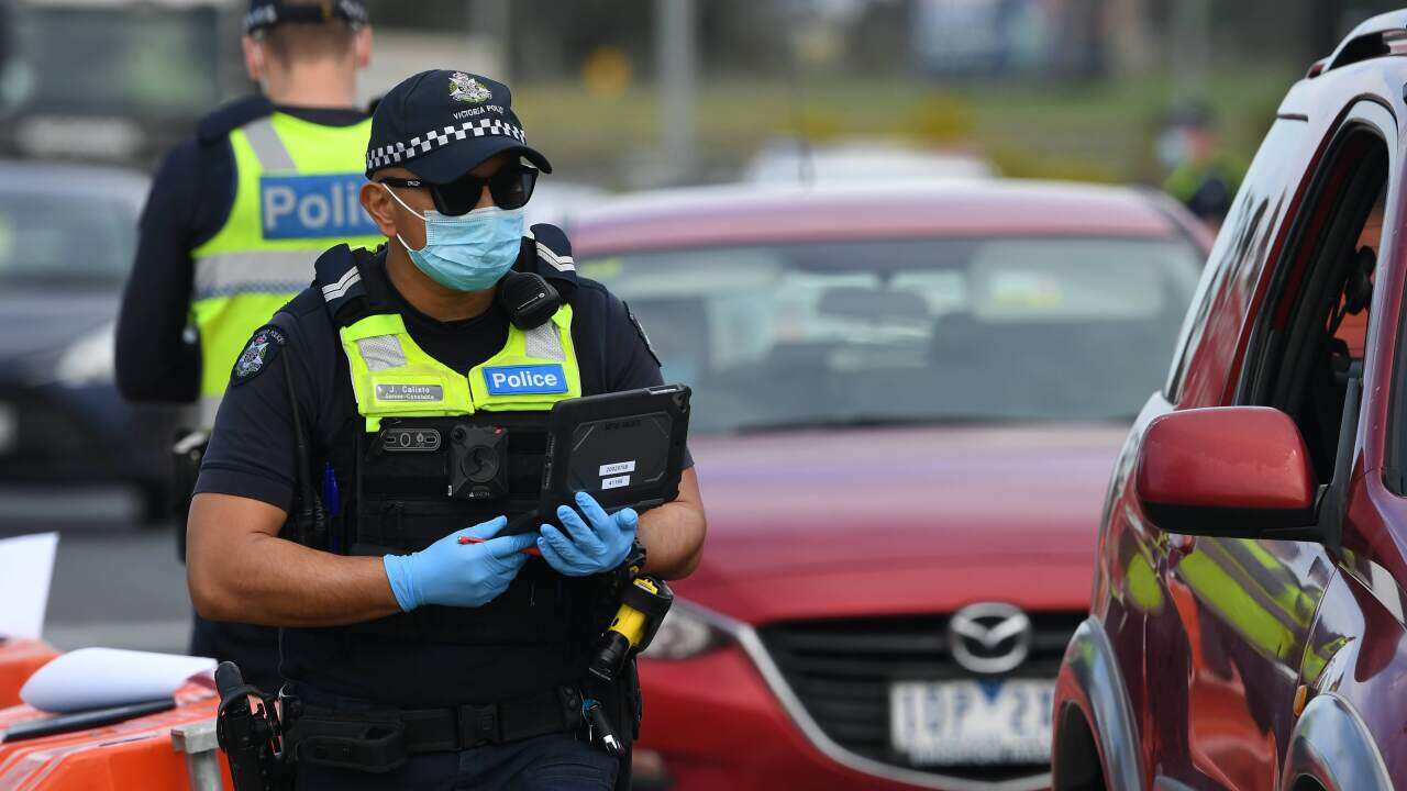 Victoria Police and ADF personnel are seen at work at a roadside checkpoint near Donnybrook, Victoria.