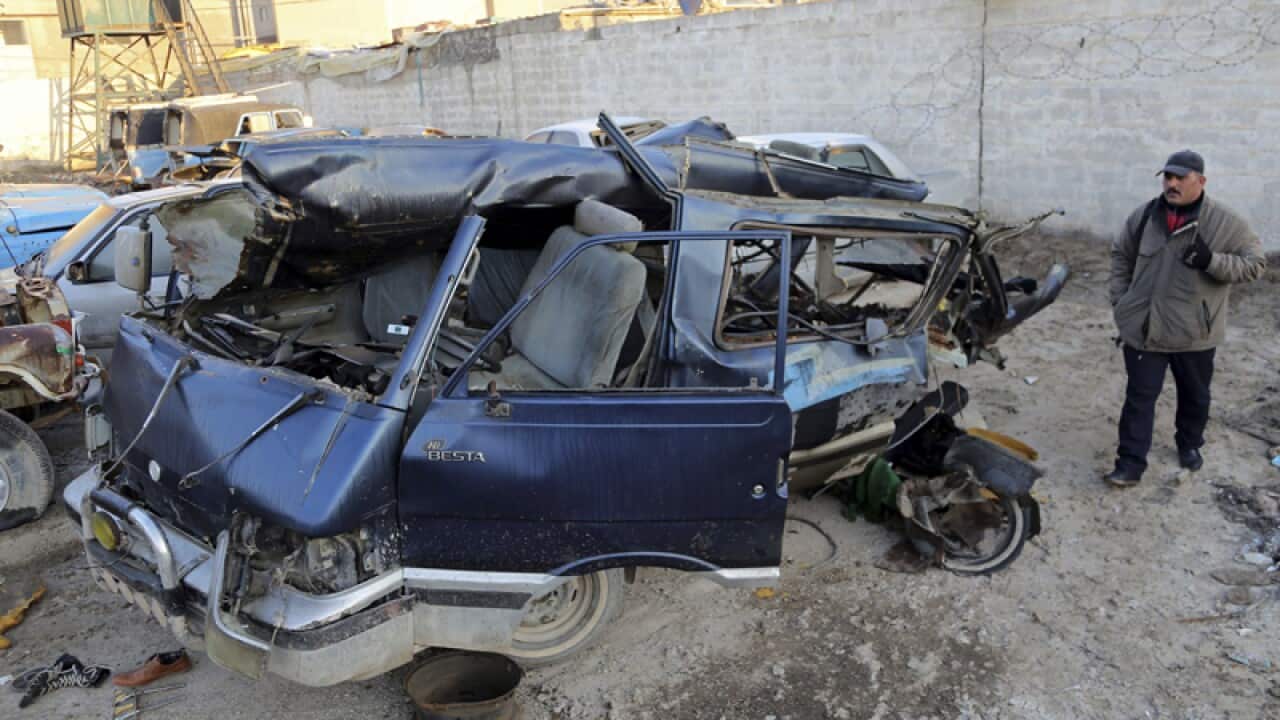 An Iraqi man inspects the damage after a car bomb attack