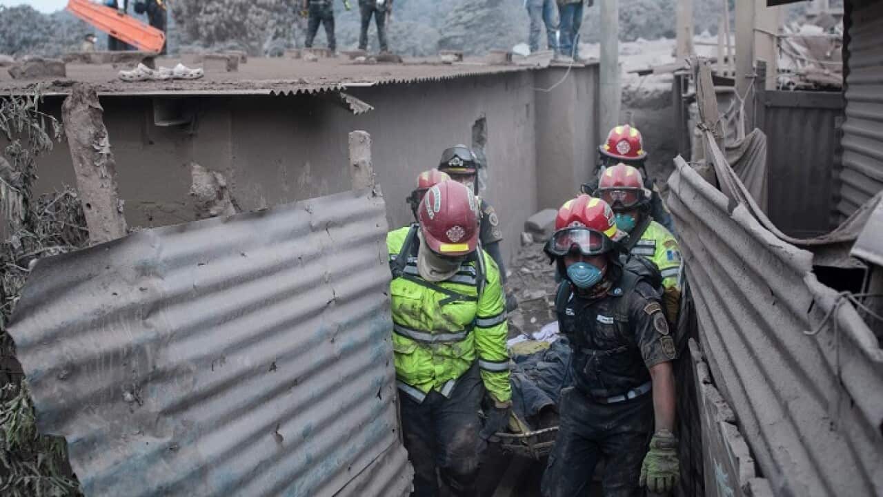 Firefighters remove a body recovered near the Volcan de Fuego, or "Volcano of Fire," in Escuintla.