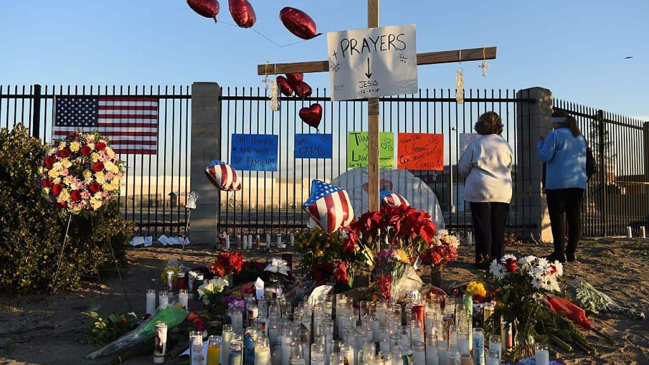 People pray at a makeshift memorial for the victims of a mass shooting near the Inland Regional Center in San Bernardino