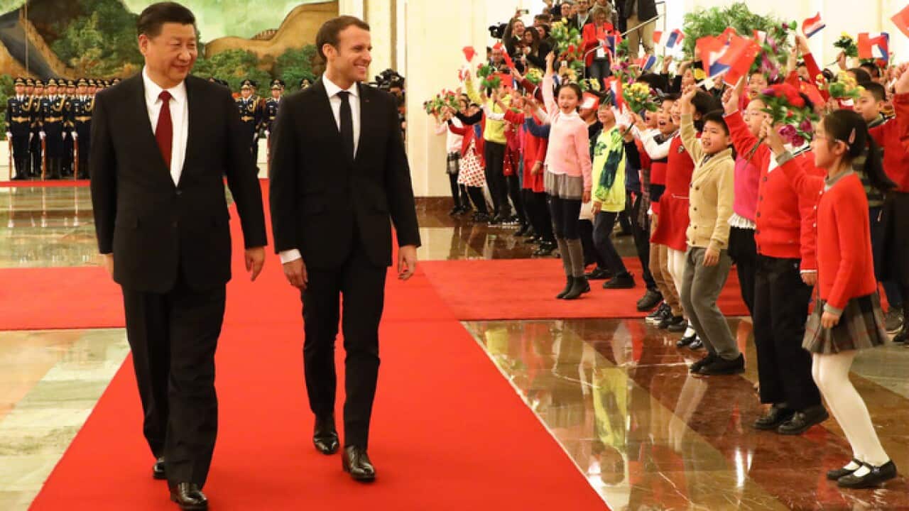 French President Emmanuel Macron (2nd L) walks with Chinese President Xi Jinping