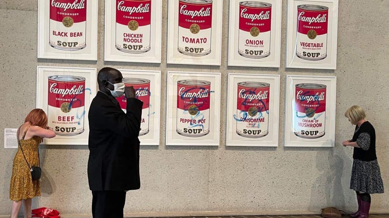 Andy Warhol's painting of soup cans is defaced with blue writing.