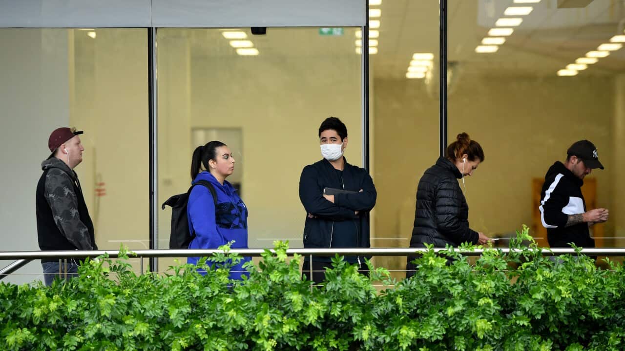 People are seen queuing outside a Centrelink office in Bondi Junction, Sydney, Tuesday, March 24, 2020