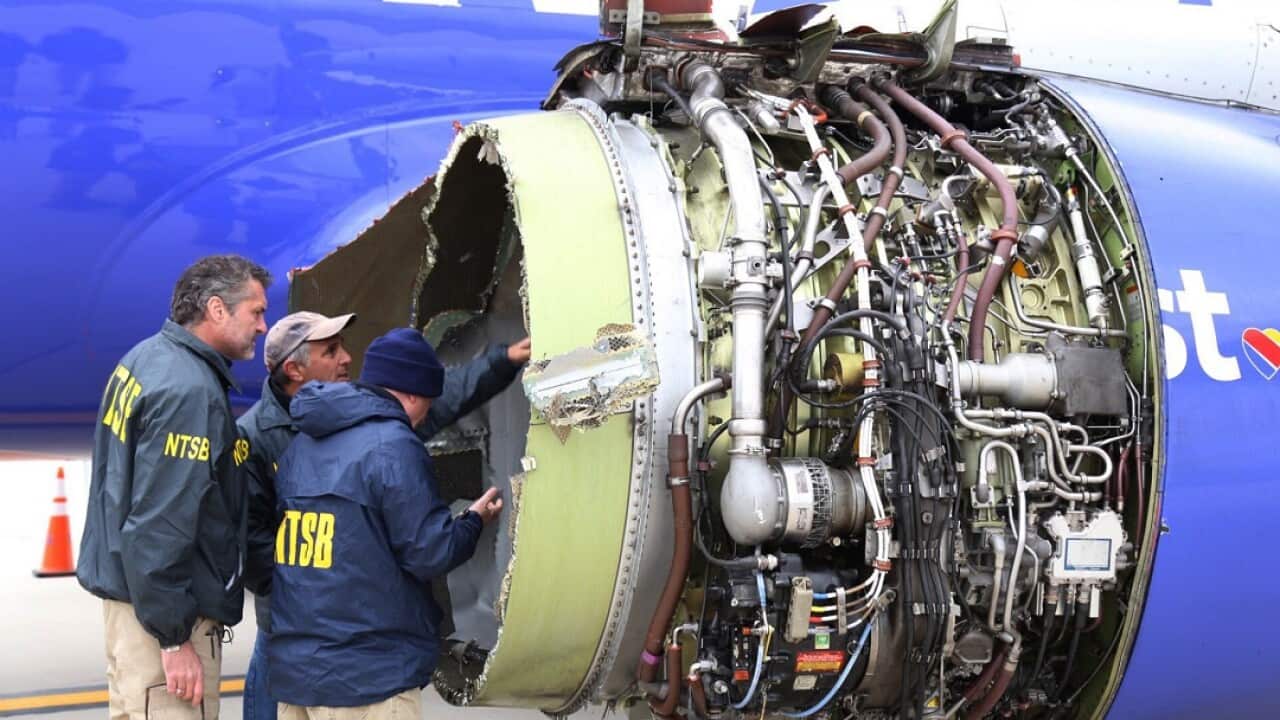 NTSB investigators examine the damage to the engine of the Southwest Airlines plane.