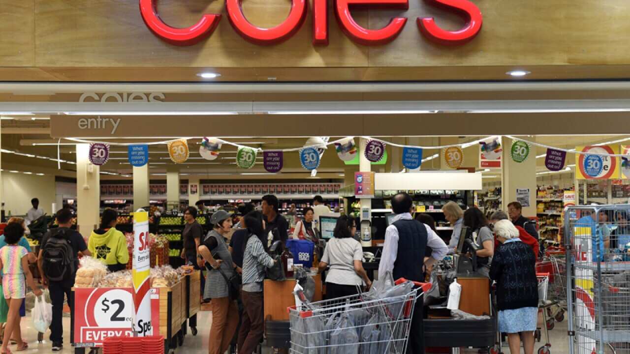 Shoppers queue at the registers at a Coles supermarket.
