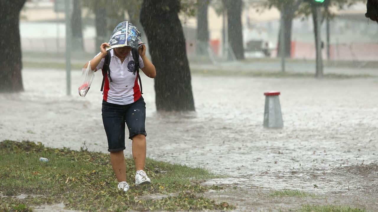 A pedestrian looks to get out of heavy rain as Batman Avenue is flooded as massive storms hit Melbourne city.