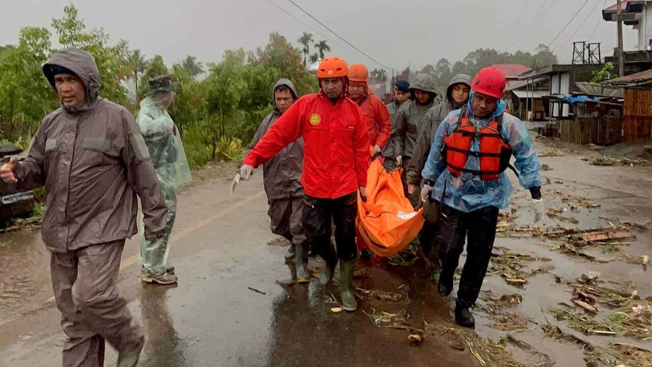 emergency responders carrying the body of a flood victim in Malalak, Padang Pariaman, West Sumatra province, Indonesia
