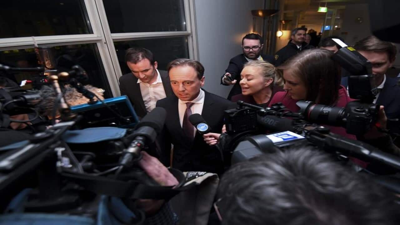 Minister for Health Greg Hunt (C) speaks to the media