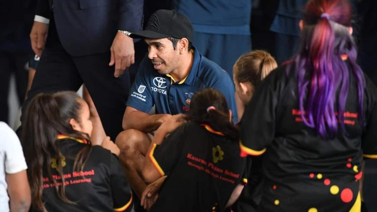 Adelaide Crows player Eddie Betts speaks with indigenous children