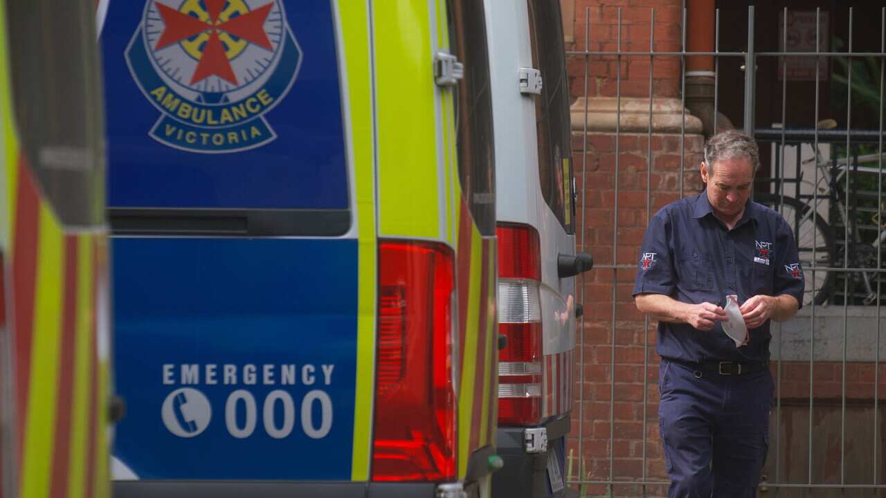 Paramedics are seen tending to their ambulance outside St Vincent hospital in Melbourne