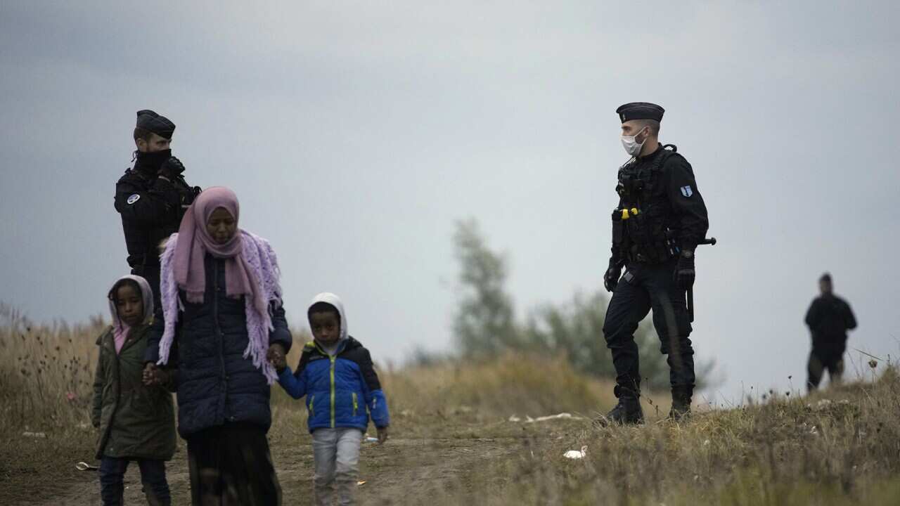 Police patrol a migrant camp in northern France