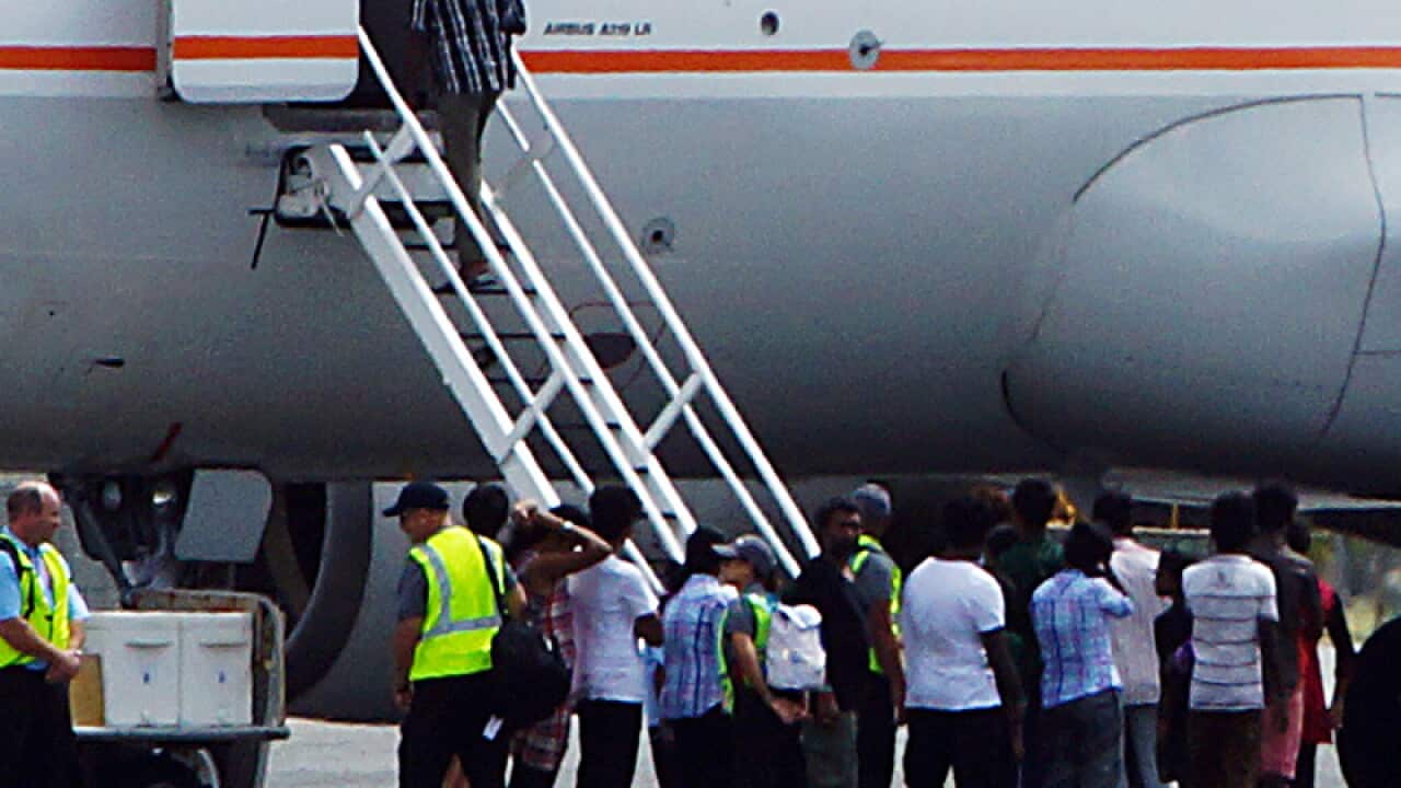 Asylum seekers board an airplane on Cocos Island