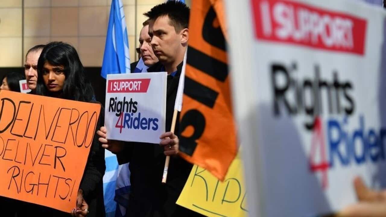Protesters hold placards during a delivery drivers rally ahead