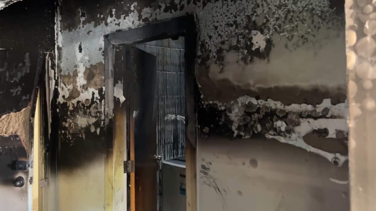 A heavily fire-charred wall and door